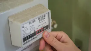 Inimene kontrollib elektriarvestit koduses keskkonnas, et jälgida igapäevast energiatarbimist ja kulusid.