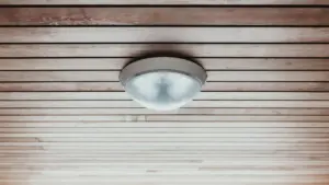 Ümmargune laelamp puidust lae all, mis meenutab kodu suitsuanduri asukohta.