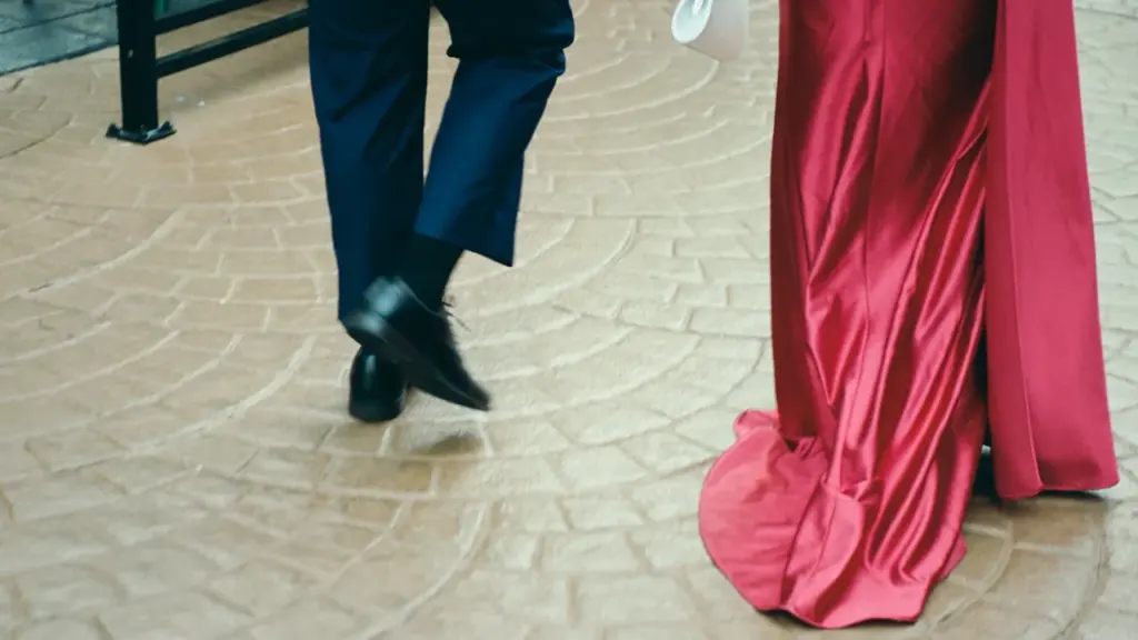 Paar pidulikus riietuses kõndimas elegantsel põrandal Rakvere ilu- ja moeõhtu eel.