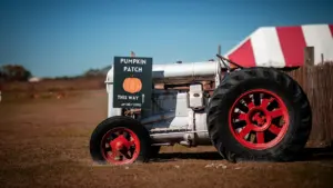 Vanaaegne traktor sügislaada sildiga seisab sügisesel põllul päikeselisel päeval Hüüru lähedal.